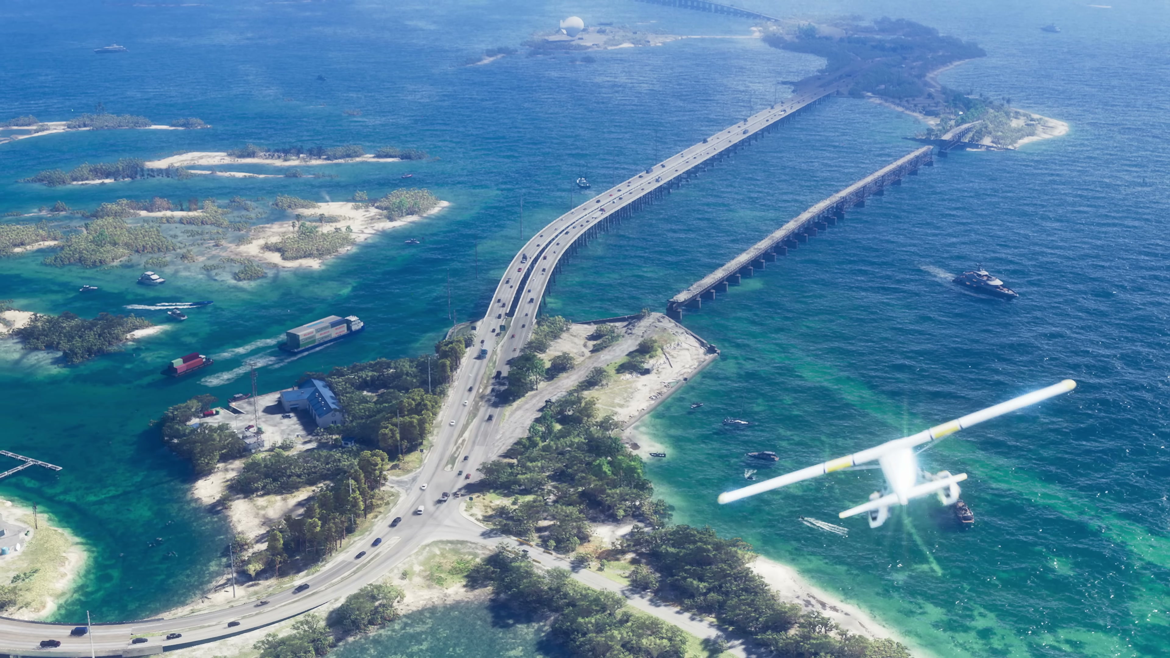 Aerial of a long bridge spanning turquoise water with a seaplane and small islands