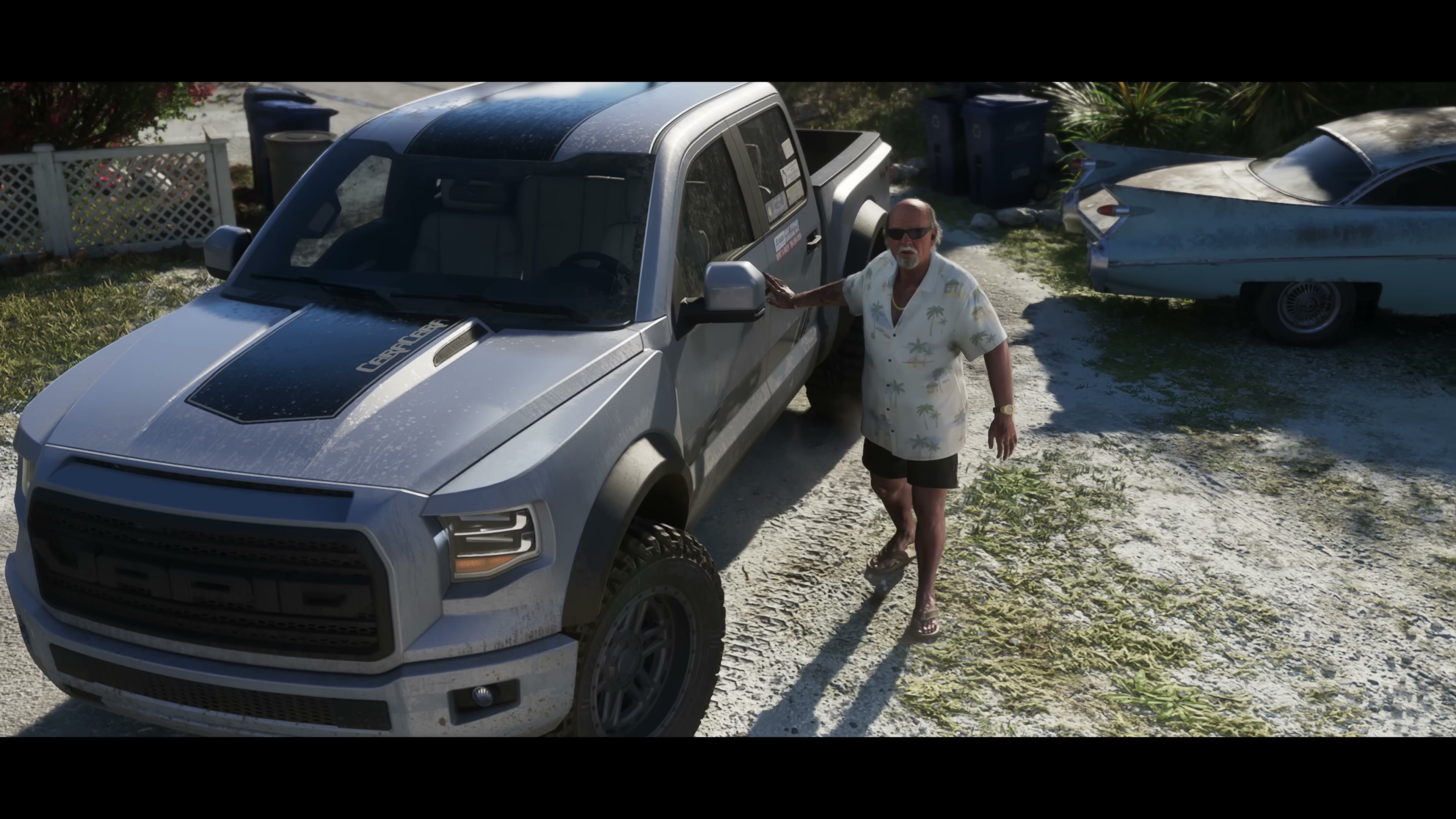 Older man with grey moustache in tropical shirt beside silver pickup truck