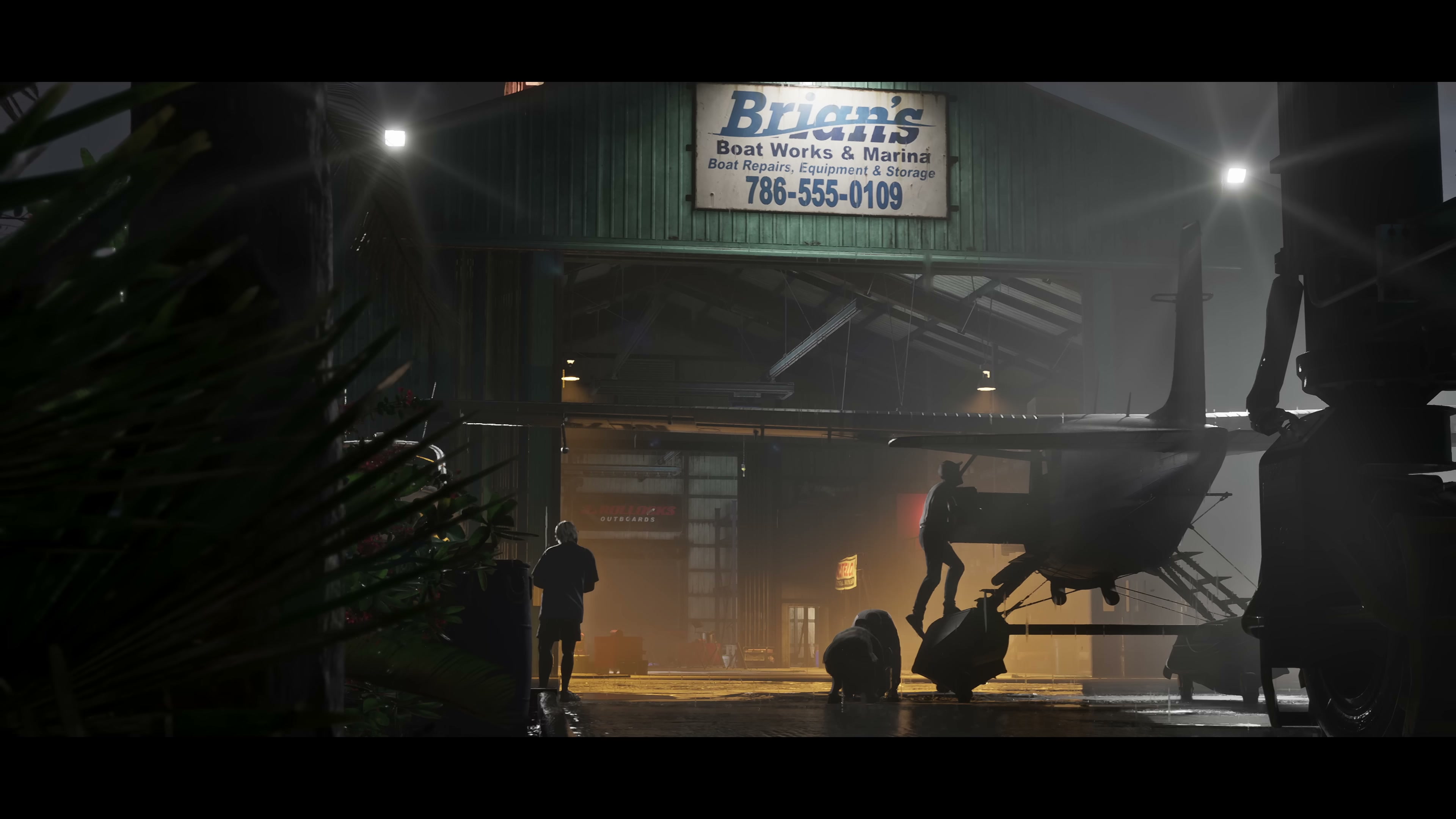 Brian's Boat Works & Marina warehouse at night with silhouetted figures working inside.